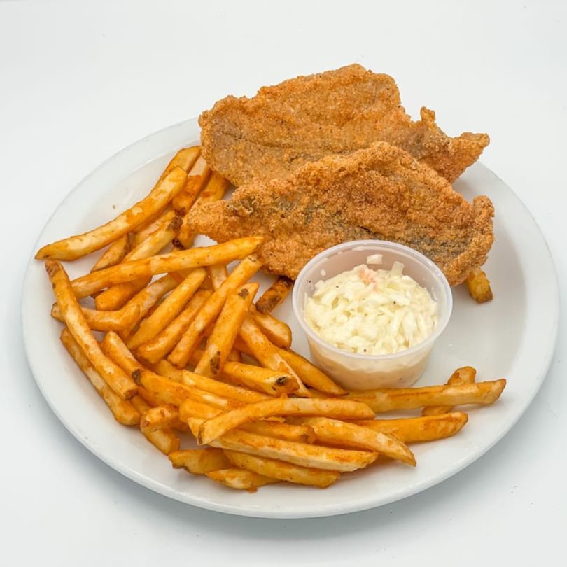 Crispy fried chicken fillets, golden french fries, and a side of coleslaw on a white plate.