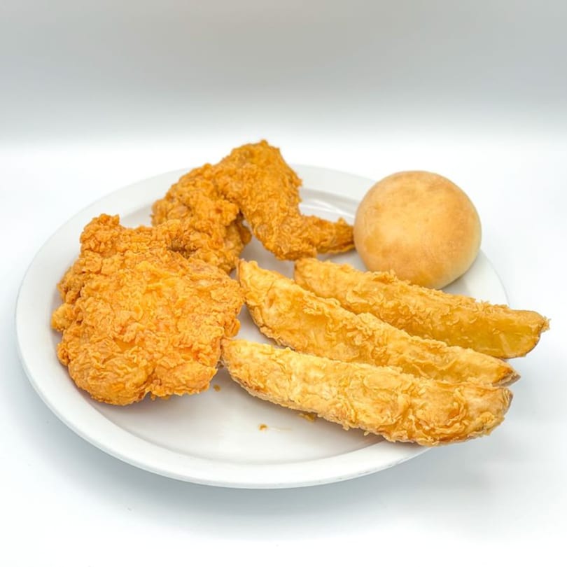 Crazy Bob's Cajun Chicken meal with crispy fried chicken pieces, potato wedges, and a dinner roll.