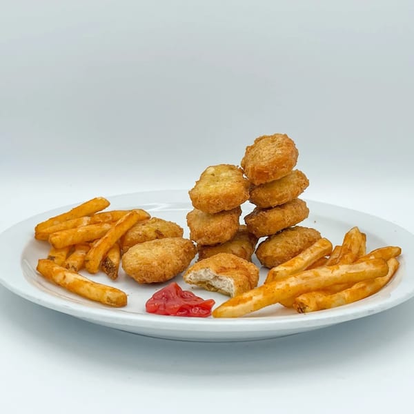 Crazy Bob's Cajun Chicken nuggets and fries with ketchup on a white plate.